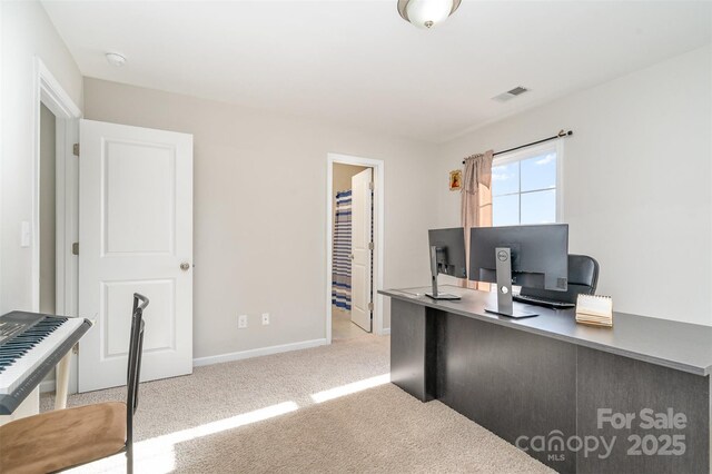 home office featuring baseboards, visible vents, and light colored carpet