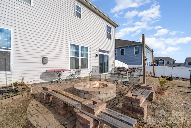 rear view of property with a patio area, an outdoor fire pit, and fence