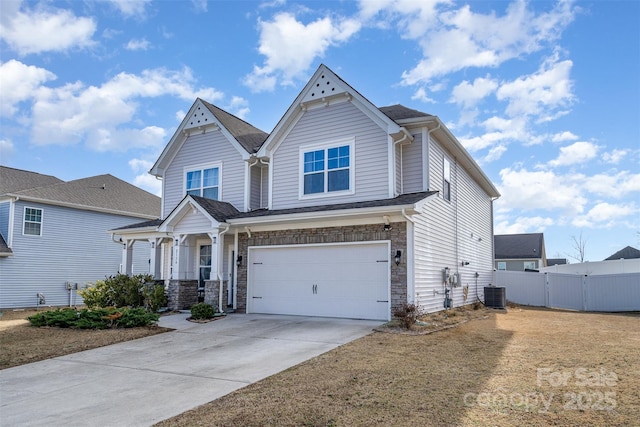 view of front of property with central AC unit, an attached garage, fence, driveway, and stone siding