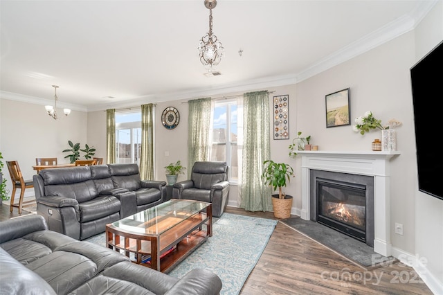 living room featuring baseboards, visible vents, a fireplace with flush hearth, ornamental molding, and wood finished floors