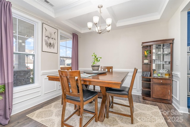 dining area featuring coffered ceiling, visible vents, a chandelier, and wood finished floors