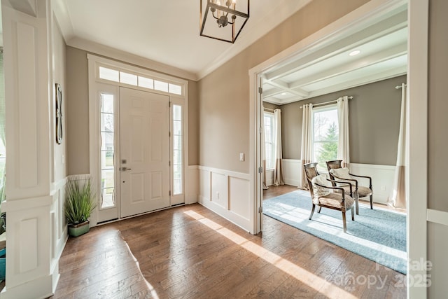 entryway featuring beam ceiling, crown molding, wood-type flooring, wainscoting, and coffered ceiling