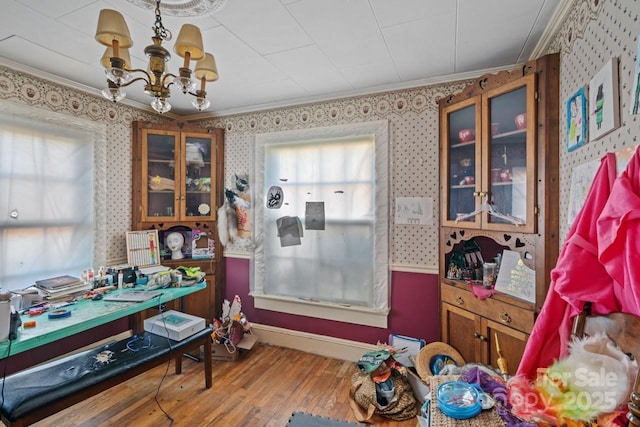 interior space featuring hardwood / wood-style flooring, crown molding, and a notable chandelier