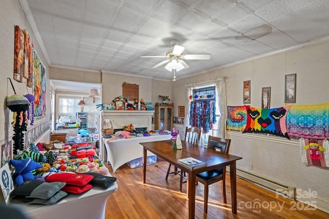 interior space with wood-type flooring, ornamental molding, and ceiling fan