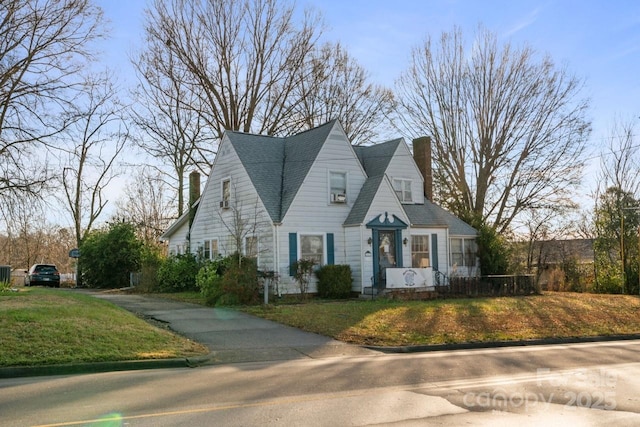 new england style home featuring a front lawn