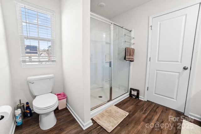 bathroom featuring hardwood / wood-style flooring, toilet, and walk in shower