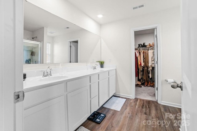 bathroom featuring vanity, wood-type flooring, and walk in shower