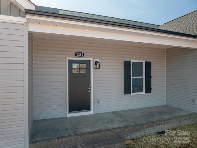 view of exterior entry featuring covered porch