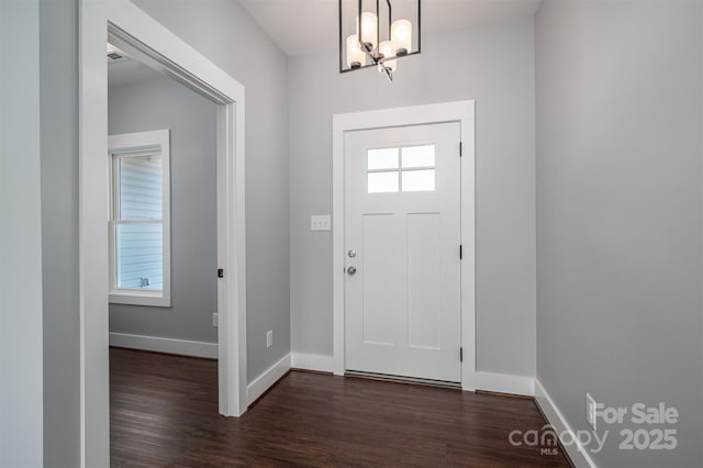 entryway featuring dark hardwood / wood-style flooring and an inviting chandelier