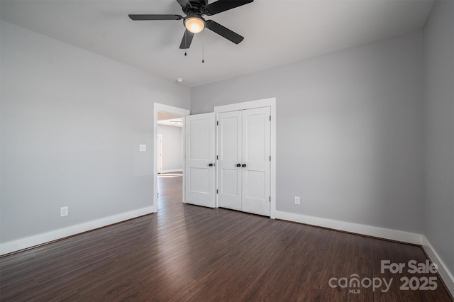 unfurnished bedroom featuring a closet, dark hardwood / wood-style floors, and ceiling fan