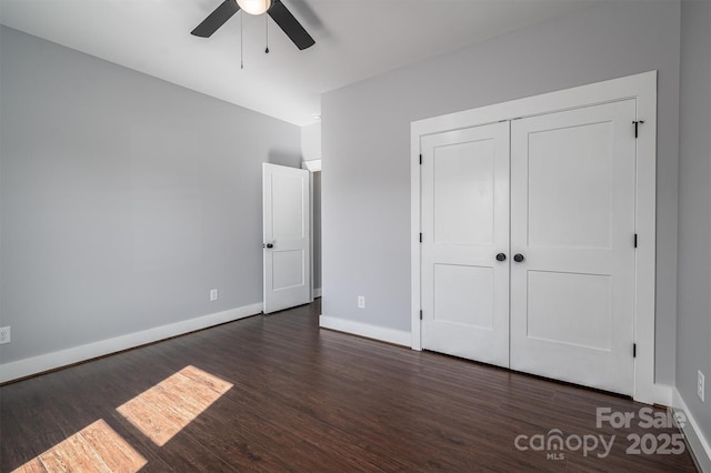 unfurnished bedroom with ceiling fan, dark hardwood / wood-style floors, and a closet