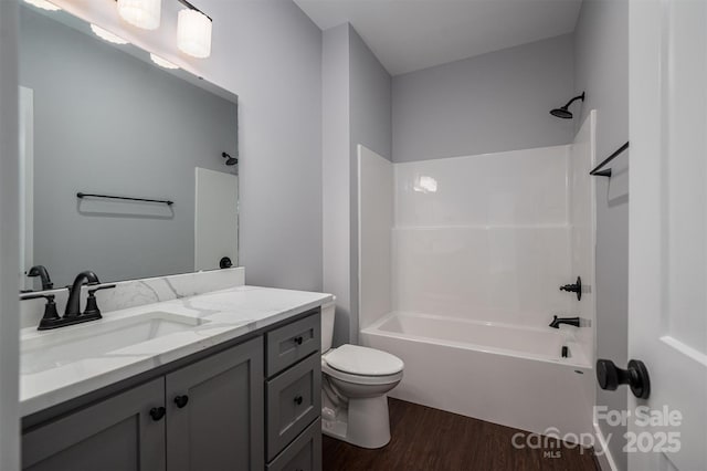 full bathroom featuring toilet,  shower combination, vanity, and wood-type flooring