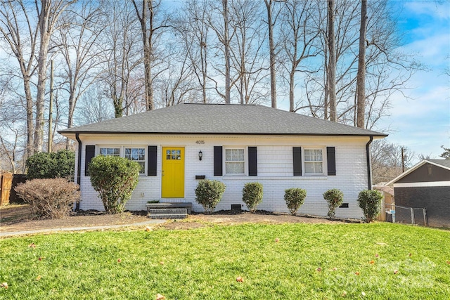 view of front of property featuring crawl space, brick siding, fence, and a front lawn