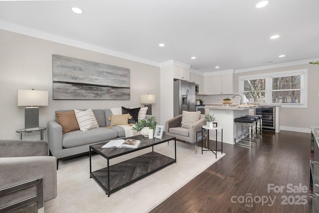 living room featuring beverage cooler, ornamental molding, hardwood / wood-style floors, and recessed lighting