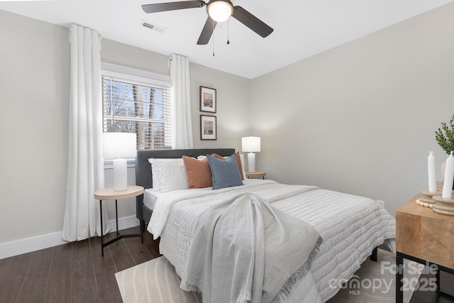 bedroom with a ceiling fan, baseboards, visible vents, and wood finished floors