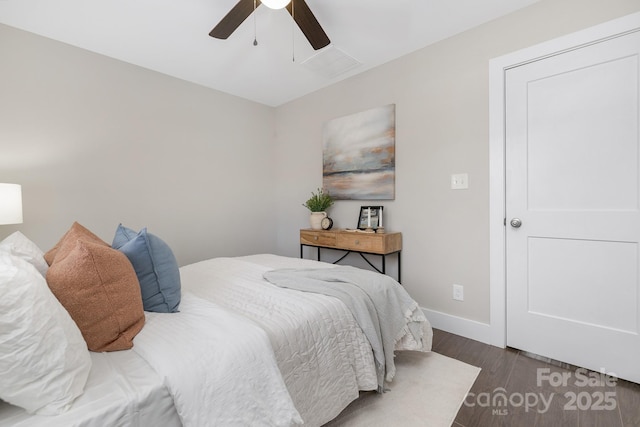 bedroom featuring a ceiling fan, visible vents, baseboards, and wood finished floors