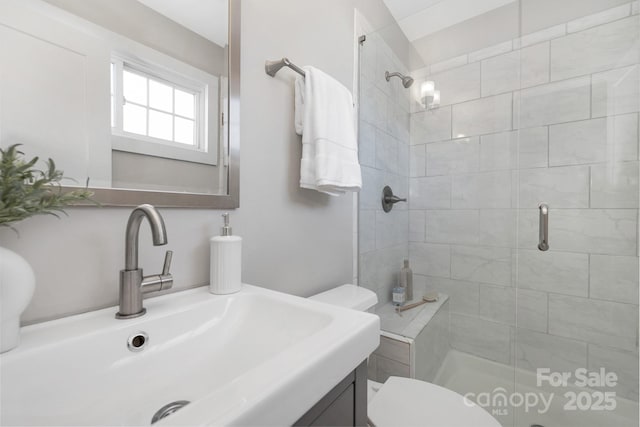 full bathroom featuring a stall shower, vanity, and toilet