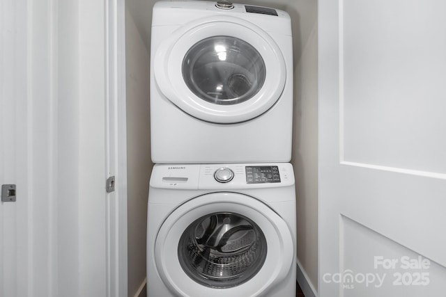 clothes washing area with stacked washing maching and dryer and laundry area