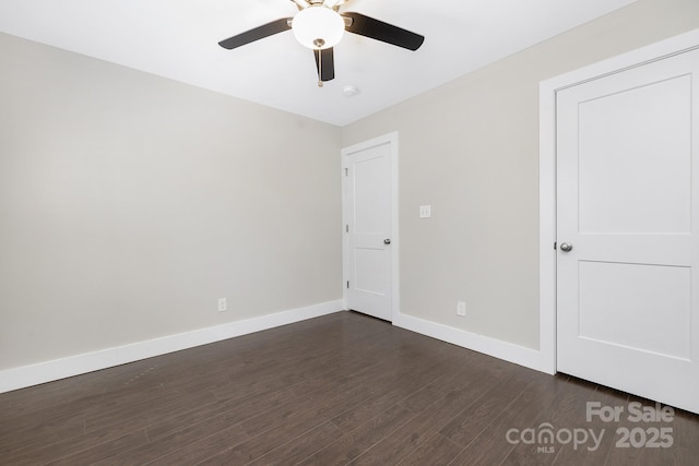 unfurnished bedroom with ceiling fan, dark wood-type flooring, and baseboards