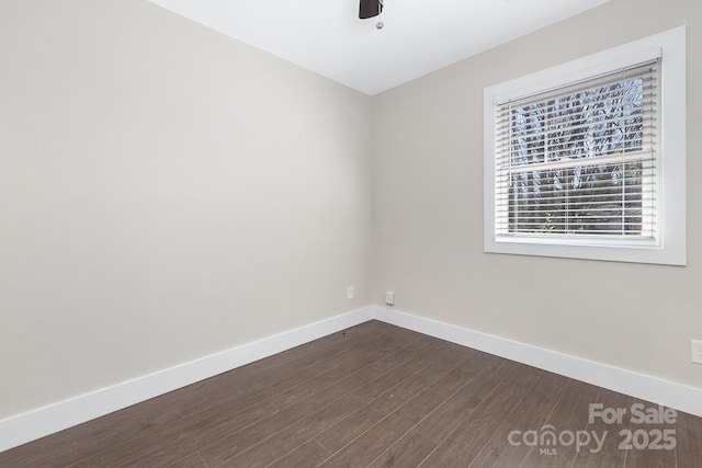 empty room with dark wood-style floors and baseboards