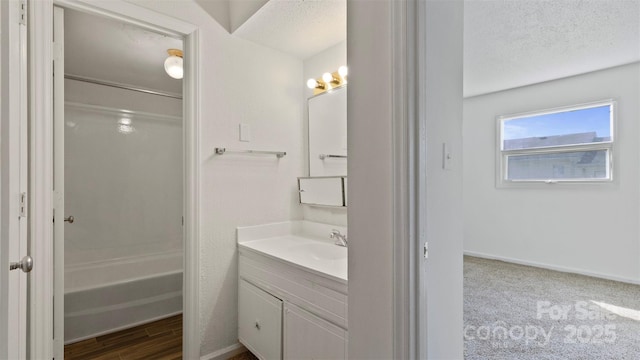 bathroom with a textured ceiling, hardwood / wood-style floors, and vanity