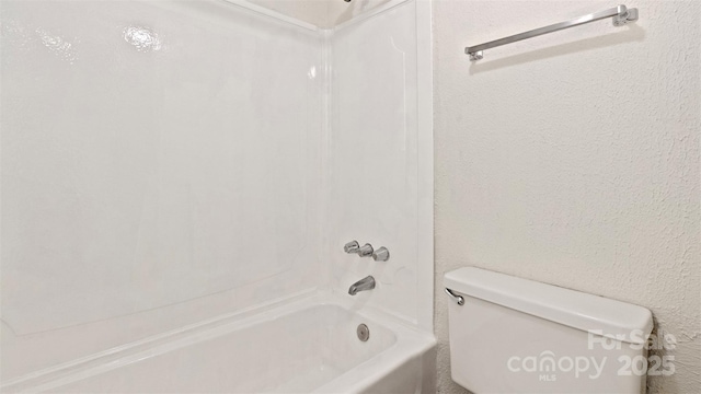 bathroom featuring washtub / shower combination and toilet