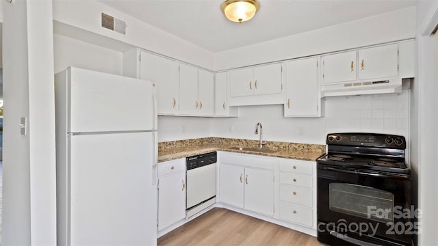 kitchen with white cabinets, sink, white appliances, and dark stone counters