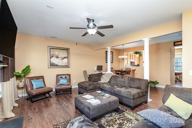 living area with dark wood-type flooring, baseboards, ornate columns, and ceiling fan with notable chandelier