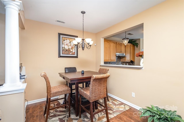 dining room featuring dark wood finished floors, decorative columns, visible vents, and baseboards