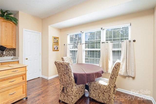 dining space featuring dark wood-style flooring and baseboards