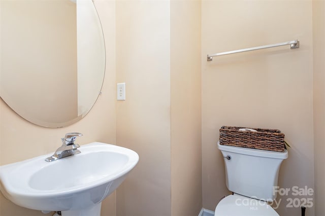 half bathroom featuring a sink and toilet