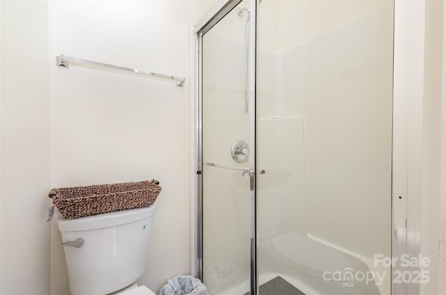 bathroom with toilet and a shower stall