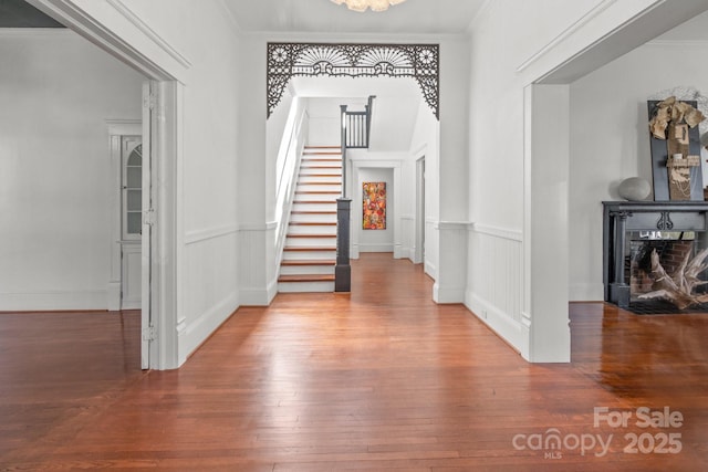 entrance foyer featuring ornamental molding and hardwood / wood-style flooring