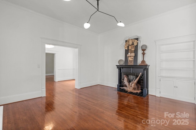 unfurnished living room with built in features, hardwood / wood-style flooring, and crown molding