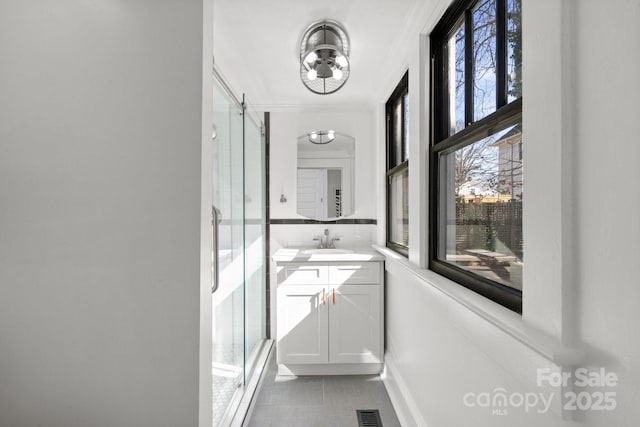 hallway featuring crown molding, light tile patterned floors, and sink