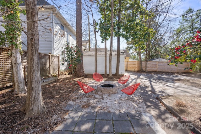 view of yard with a shed, a patio, and a fire pit