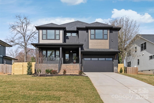 prairie-style home with a garage, fence, driveway, board and batten siding, and a front yard