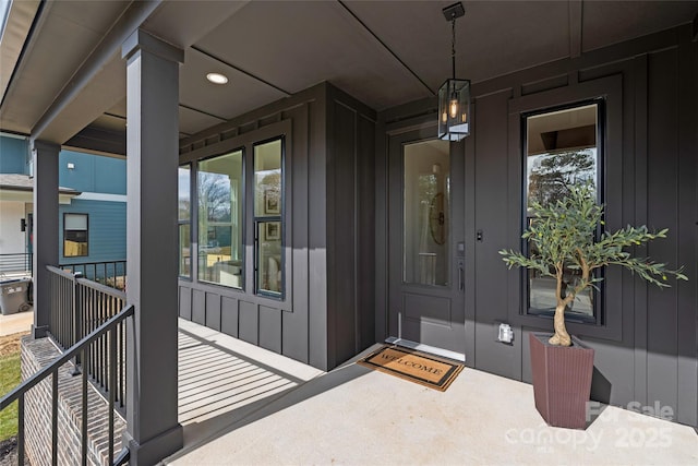 view of exterior entry with a porch and board and batten siding