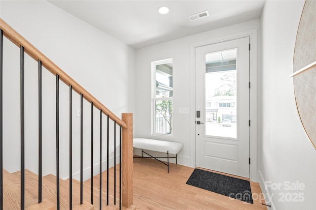 foyer entrance with stairway, recessed lighting, visible vents, and light wood-style floors