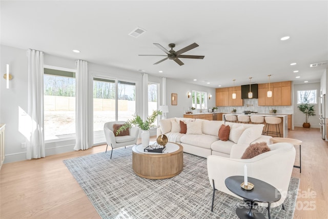 living area featuring light wood-type flooring, visible vents, and recessed lighting