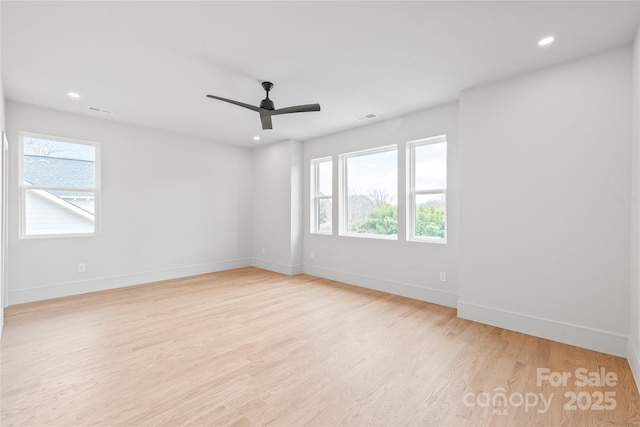 empty room featuring recessed lighting, light wood-type flooring, visible vents, and a healthy amount of sunlight