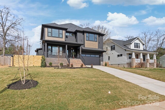 prairie-style home featuring driveway, a porch, a front lawn, and fence