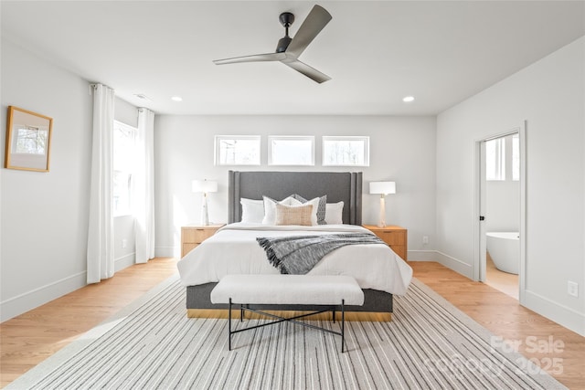 bedroom with light wood finished floors, ensuite bath, baseboards, and recessed lighting