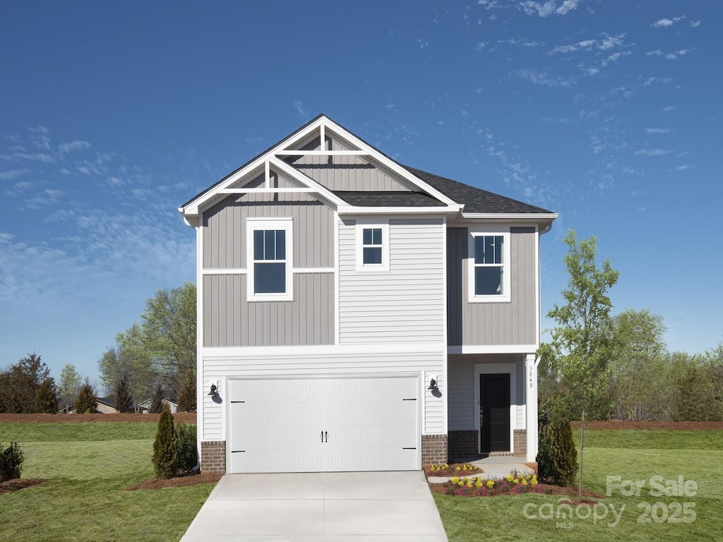 view of front of property with an attached garage, brick siding, concrete driveway, board and batten siding, and a front yard