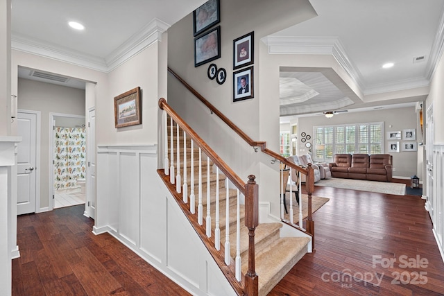 stairway featuring hardwood / wood-style flooring, visible vents, and ornamental molding