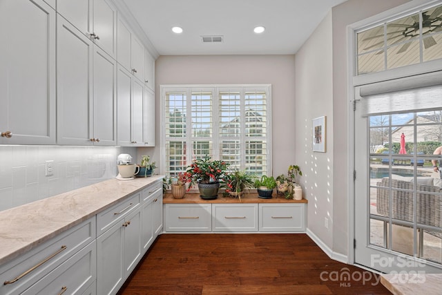 kitchen with dark wood-style floors, recessed lighting, light stone countertops, and white cabinets