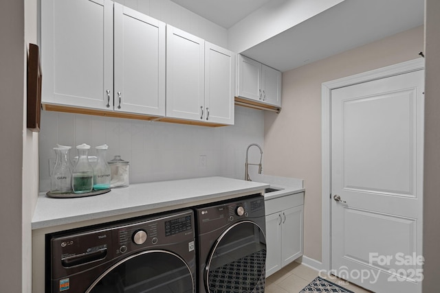 laundry area with cabinet space, washing machine and dryer, light tile patterned floors, and a sink