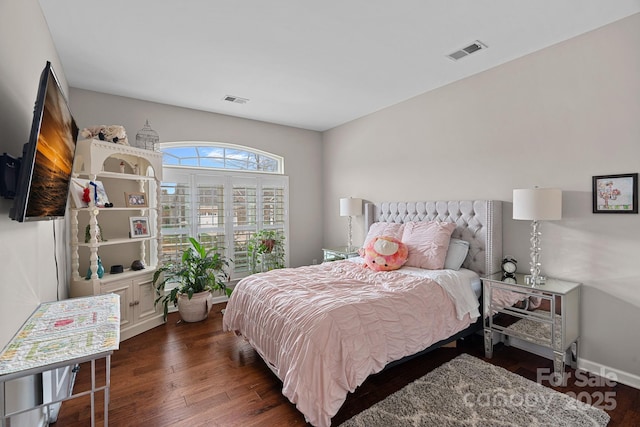 bedroom featuring visible vents, baseboards, and wood finished floors