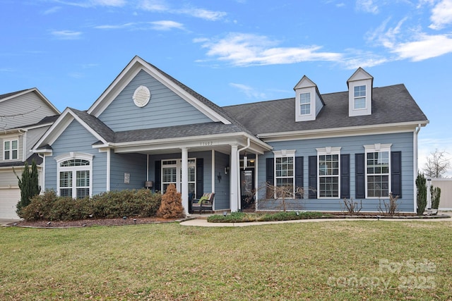 view of front of property with a front lawn, roof with shingles, and a porch