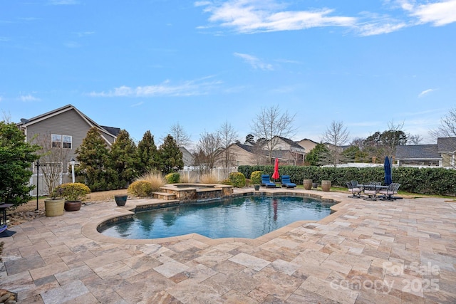 view of swimming pool with a pool with connected hot tub, a patio area, and fence